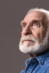 What short life. Low angle of thoughtful old man looking into the distance. Isolated on grey background