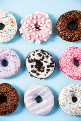 Various donuts on a colorful background. Top view shot. Sweetness, happiness conception.