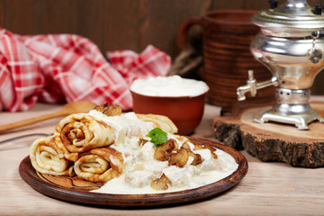 Obraz na płótnie Canvas Pancakes with meat, mushrooms and sour cream sauce. Traditional Russian cuisine. Maslenitsa.