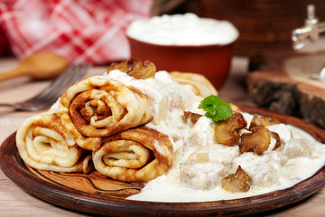 Pancakes with meat, mushrooms and sour cream sauce. Traditional Russian cuisine. Maslenitsa.