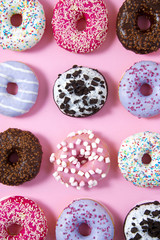 Various donuts on a colorful background. Top view shot. Sweetness, happiness conception.