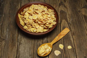 Corn flakes in a bowl on a table with milk and honey for a background. Breakfast, healthy food. Selective focus.