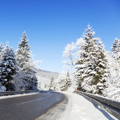 A winding asphalt road during winter