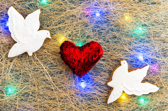 White doves and a red heart. Valentine's Day. Multicolored garland. Flat lay.
