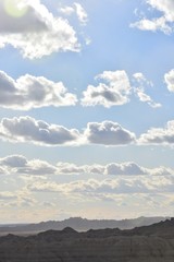 Sunny skies behind puffy clouds