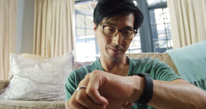 Man using smart watch in living room 