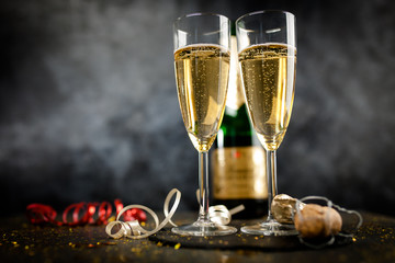 Two champagne glasses in golden glitter © George Dolgikh