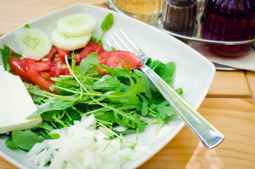 Fresh salad with feta cheese, tomatoes, cucumber and arugula leaves