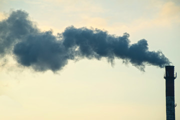 Pipe with smoke on a background of the sky close-up, with copy space.