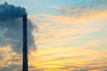 Pipe with smoke on a background of the sky close-up, with copy space.