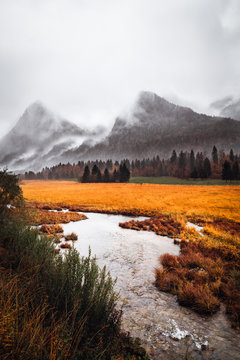 Alpen in herbstlicher Atmosph&auml;re mit Fluss im Vordergrunf