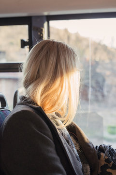 Young woman looking through a window in a bus