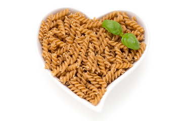 Uncooked wholemeal pasta isolated white background.