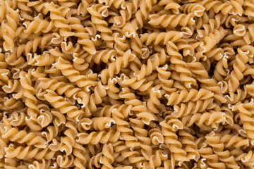 Uncooked wholemeal pasta isolated white background.