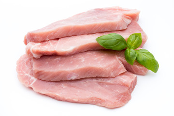 Fresh pork fillet with basil on a white background.