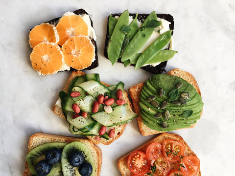 Overhead view of variety of bread toast with toppings for breakfast