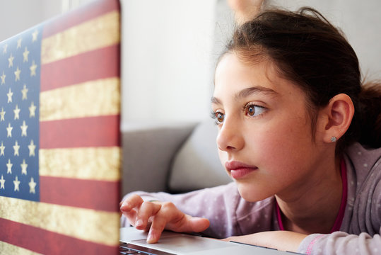 LIttle girl using her laptop at home