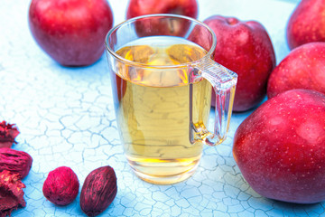 Apple juice and apples on wooden table .