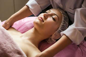 Fototapeta na wymiar calm girl having spa facial massage in luxurious beauty salon
