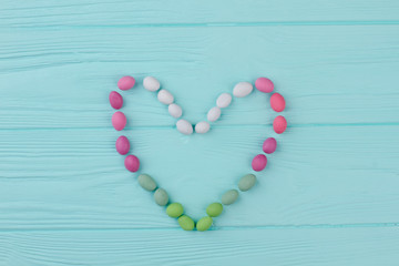 Love heart background, top view. Colorful candies on wooden background. Love and romance concept.