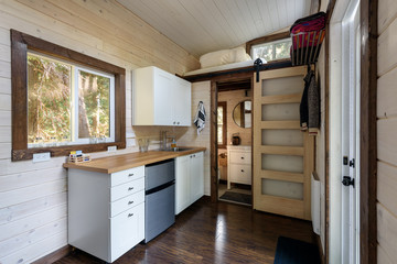 Interior design of a kitchen and bathroom in a tiny rustic log cabin.