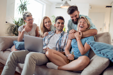 Friends enjoying using a laptop together