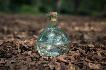 Botella de cristal transparente redonda aislada en el suelo. 