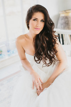 Beautiful Brunette Bride Sitting with Hands in Lap