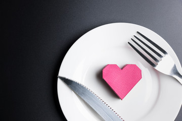 Box red heart shape in the white dish on black background with copy space.Valentine's Day, Day of love.