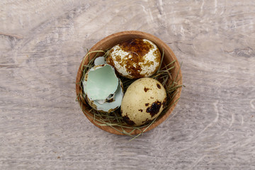 Quail eggs and eggshell on a wooden background.