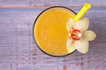 Mango banana smoothie on wooden background. View from above, top, horizontal