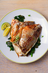 Dorado or dorada fish fillet with spinach, thyme and lime. View from above, top, vertical