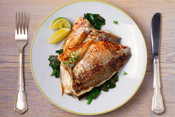 Dorado or dorada fish fillet with spinach, thyme and lime. View from above, top, horizontal