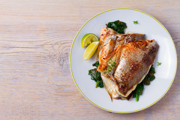 Dorado or dorada fish fillet with spinach, thyme and lime. View from above, top, horizontal