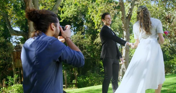 Photographer taking photo of groom and bride  