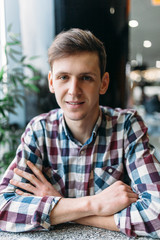 Portrait of a young man in glasses and a shirt with a positive mood and a wide smile