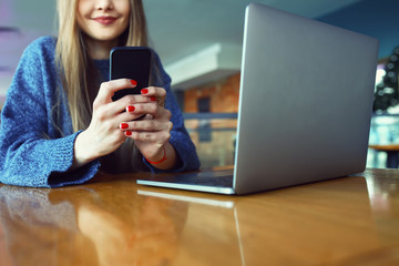 Close up of women's hands holding cell telephone with blank copy space scree for your advertising text message or promotional content, hipster girl watching video on mobile phone during coffee break