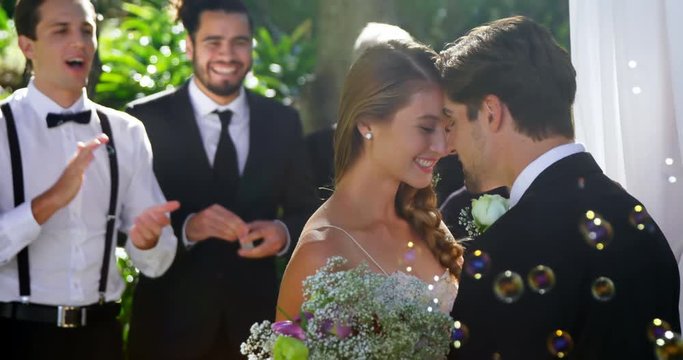Bride and groom happily hugging each other and guests clapping  