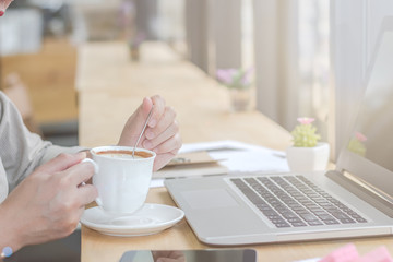 Close Up of woman hands using mobile phone and laptop computer with blank copy space screen for your advertising text message or content business at a coffee shop with a document.