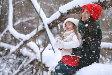 A winter fairy tale, a young mother and her daughter ride a sled