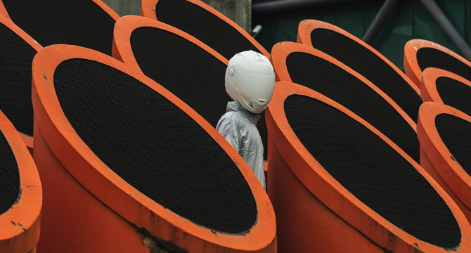 Abstract scene with person with white helmet/mask and silver jacket .