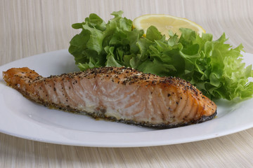 Roasted salmon fillet. Fried fish with salad on a plate.