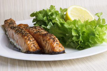 Roasted salmon fillet. Fried fish with salad on a plate.