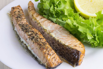 Roasted salmon fillet. Fried fish with salad on a plate.