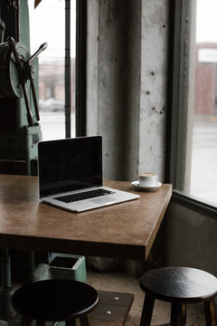 laptop on table in coffee shop with industrial feel