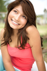 Young Hispanic girl smiling outside.