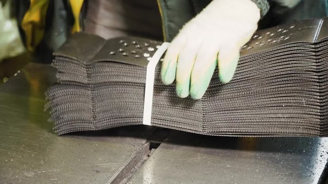 A worker holds the geogrid in a stack in the plant.