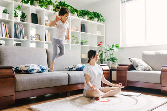 Adorable little girl doing yoga with her mother