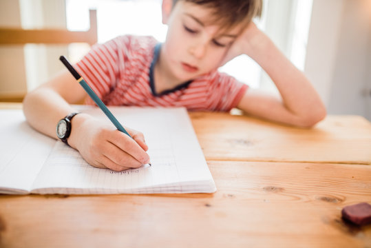 child writing in notebook