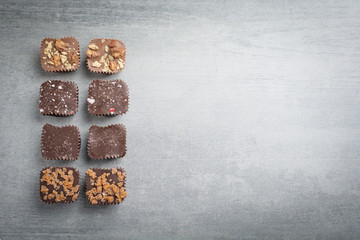Several kinds of chocolate treats on a stone background.